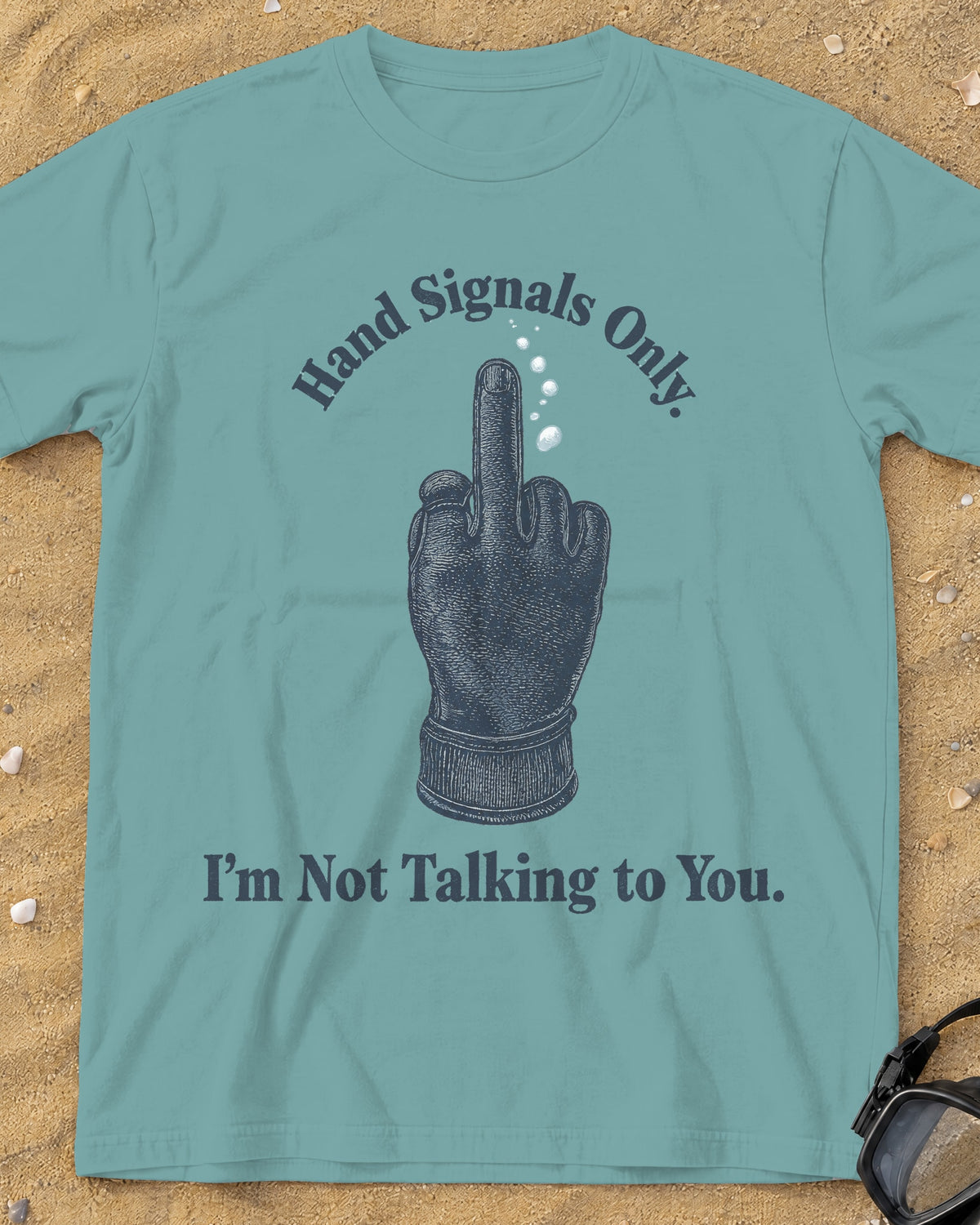 Seafoam Hand Signals Only tee on a sandy beach