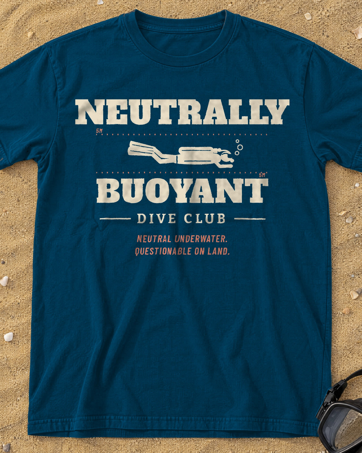 Denim Neutrally Buoyant Dive Club tee on a sandy beach