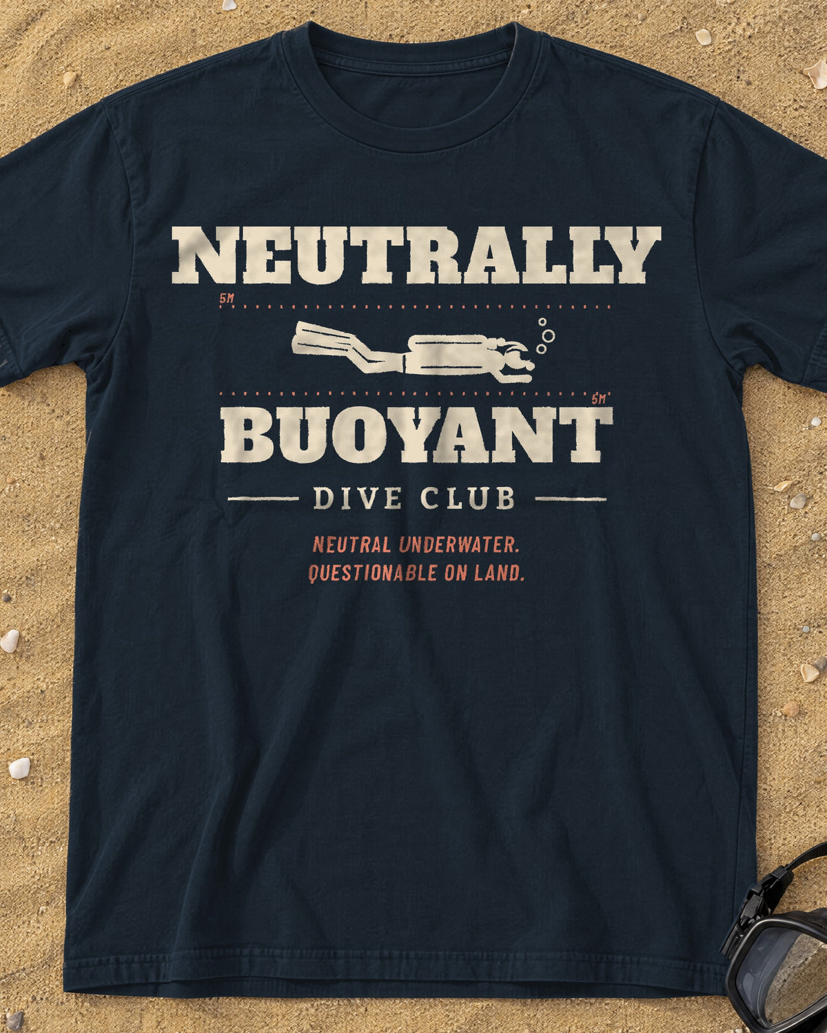 Graphite Neutrally Buoyant Dive Club tee on a sandy beach